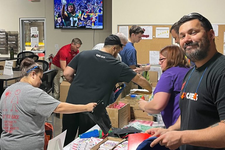 group of employees packing school supply boxes