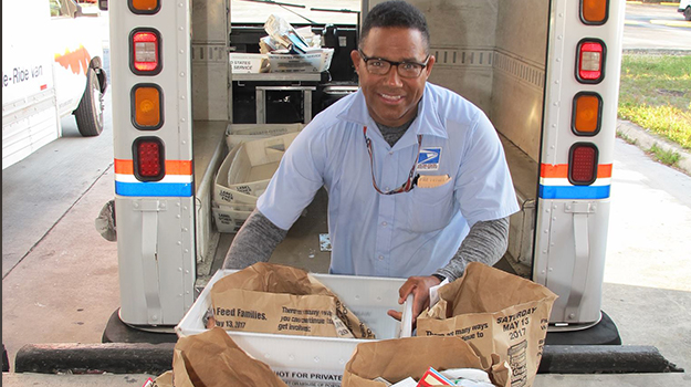 Letter carrier putting food items into truck