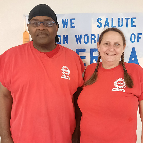 two union workers with red shirts standing side by side