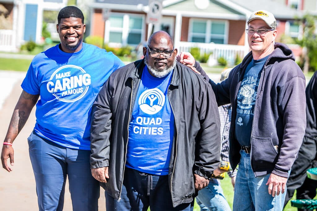 three volunteers posing for a picture outside