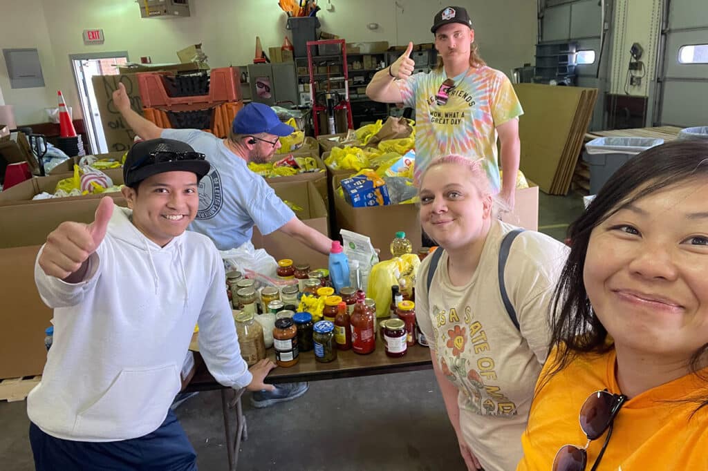 group of volunteers sorting bags of food at a food drive