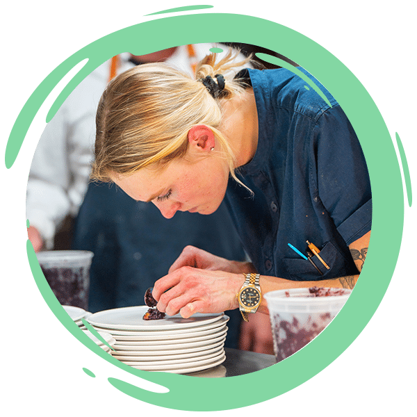 chef leaning down plating food
