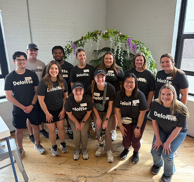 group of volunteers in black shirts standing together inside