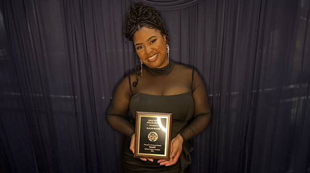 woman in a black dress holding an award plaque