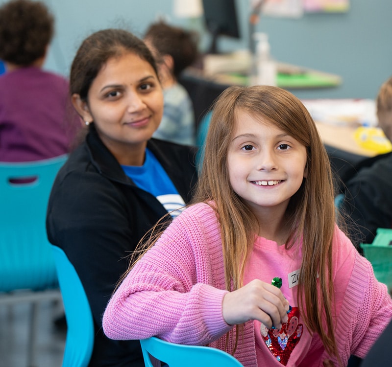 student and volunteer sitting together in a cafeteria