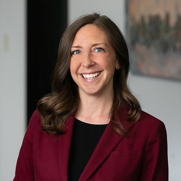 woman in a maroon blazer smiling
