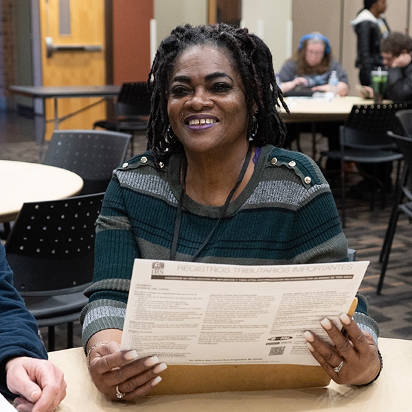 woman holding a tax form smiling