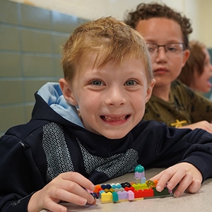 student-at-a-table-building-lego