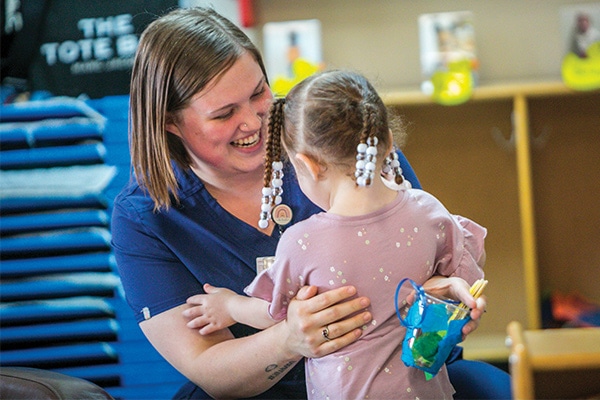 mother smiling as young daughter runs into her arms
