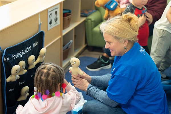 woman playing with a young child in a daycare