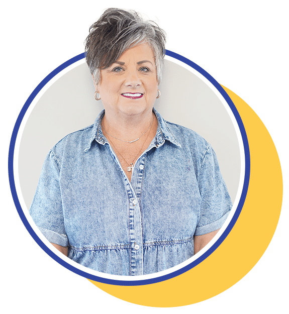 woman in a denim dress inside a circle frame smiling