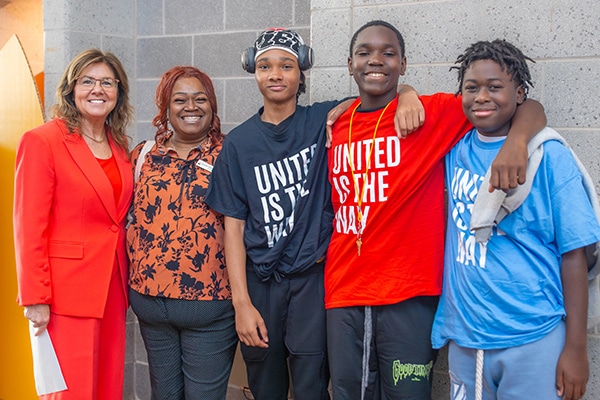 woman standing with a group of middle school age kids