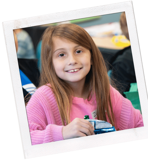 young girl with long brown hair in a pink sweater