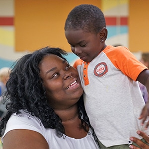mother holding her son and smiling