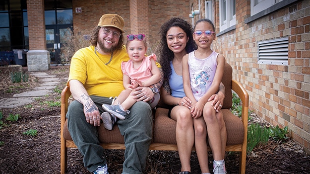 family of four sitting outside on a couch